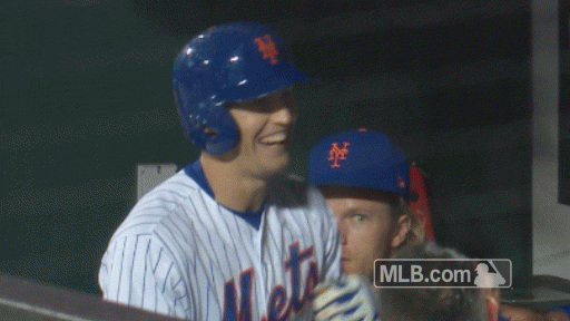 New York Mets outfielder Brandon Nimmo is congratulated by his teammates in the dugout following a home run.